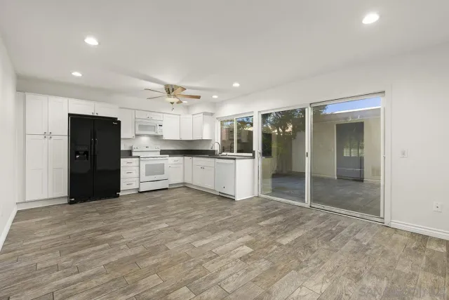 a large kitchen with a refrigerator and a stove top oven