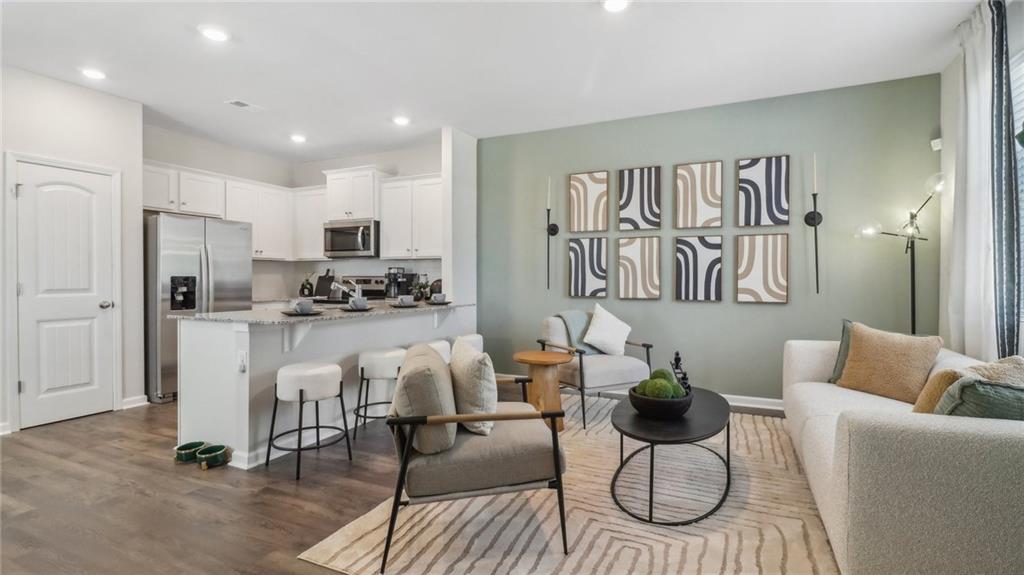 2098 Moss Hill Road Stone Mountain, GA 30083 - Photo 15 of 40 a living room with white couches and kitchen view with wooden floor