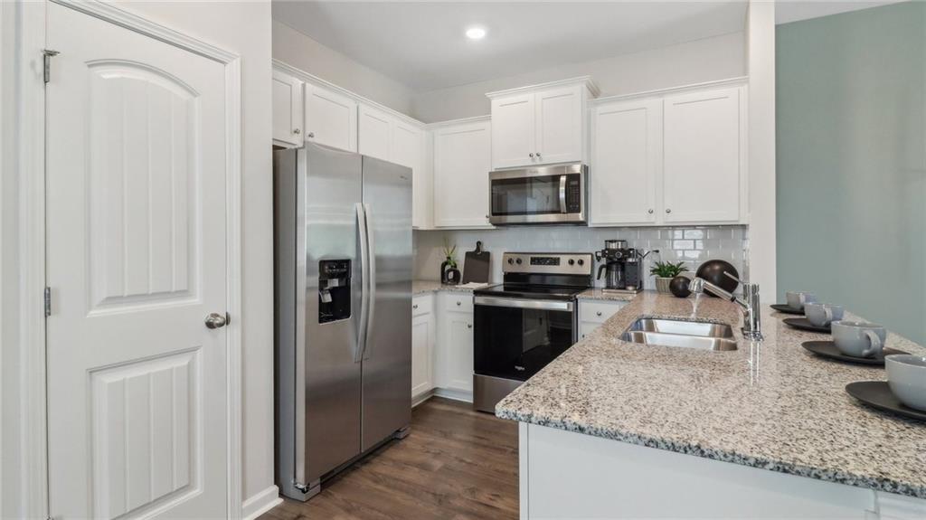 2098 Moss Hill Road Stone Mountain, GA 30083 - Photo 24 of 40 a kitchen with stainless steel appliances granite countertop a refrigerator stove and sink