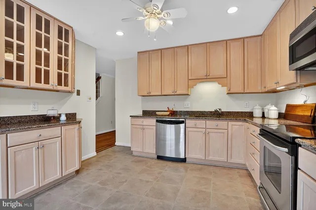 a kitchen with granite countertop a stove sink and cabinets