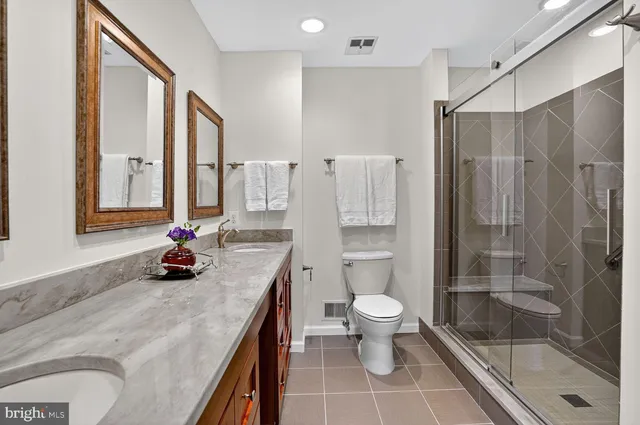 a bathroom with a double vanity sink toilet and shower