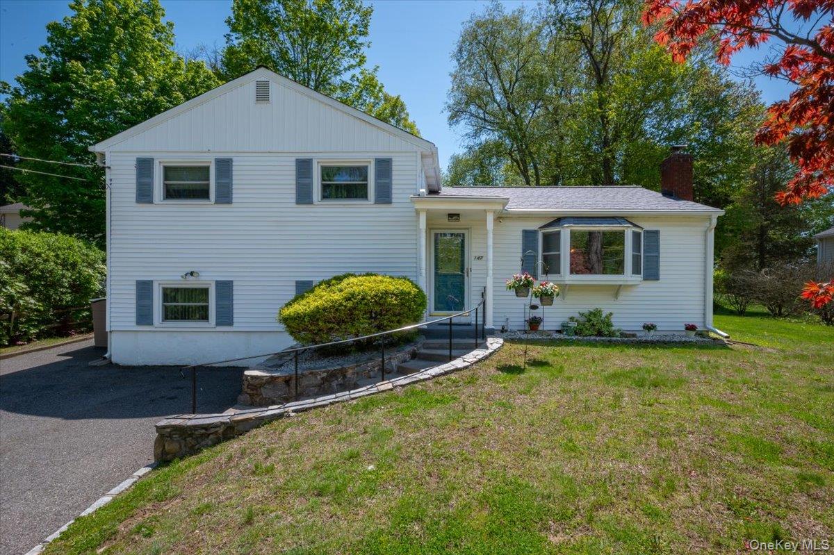 147 Lockwood Road Cortlandt Manor, NY 10567 - Photo 1 of 31 a front view of house with yard and trees in the background