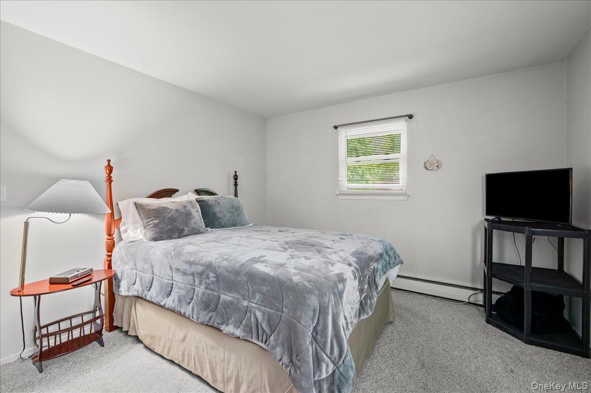 147 Lockwood Road Cortlandt Manor, NY 10567 - Photo 18 of 31 a bedroom with a bed and a flat screen tv