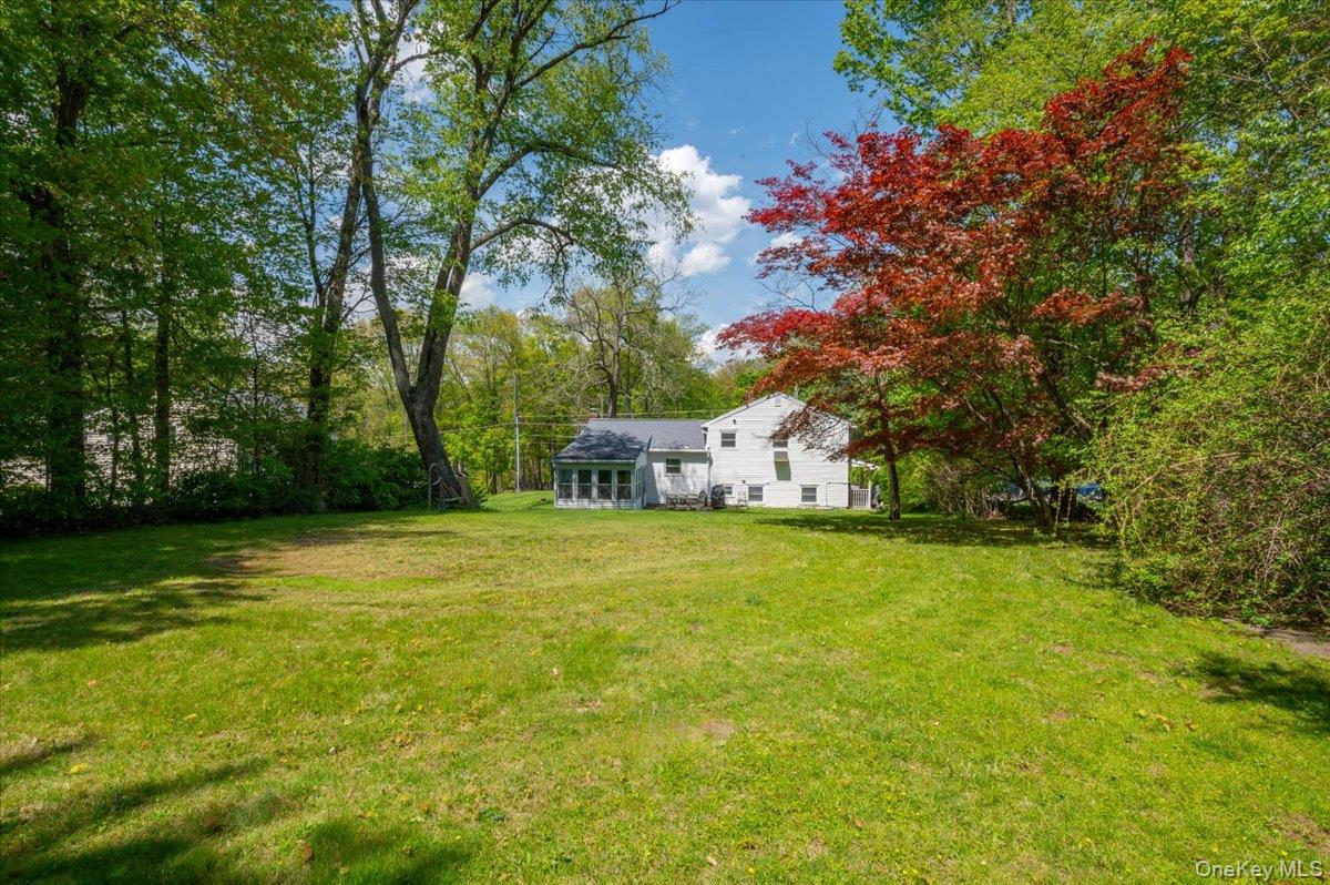 147 Lockwood Road Cortlandt Manor, NY 10567 - Photo 26 of 31 a front view of a house with a yard and trees