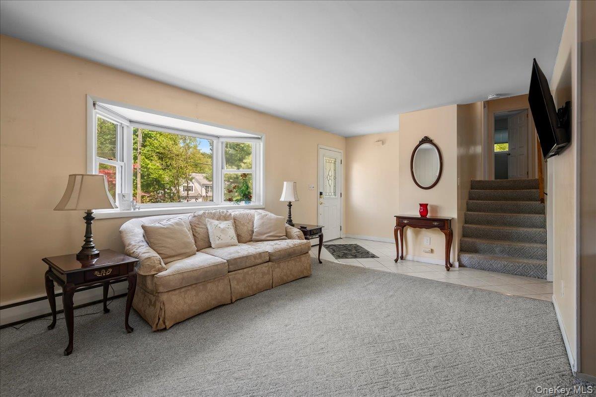 147 Lockwood Road Cortlandt Manor, NY 10567 - Photo 6 of 31 a living room with furniture a large window and a flat screen tv