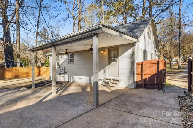 a view of a house with a wooden bench next to a road