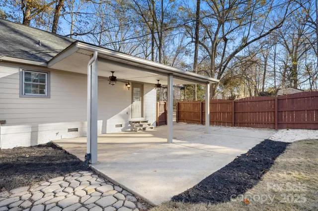 a view of a white house with a large tree