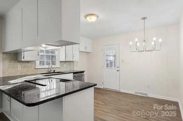 a kitchen with stainless steel appliances granite countertop a sink a microwave a refrigerator and a stove