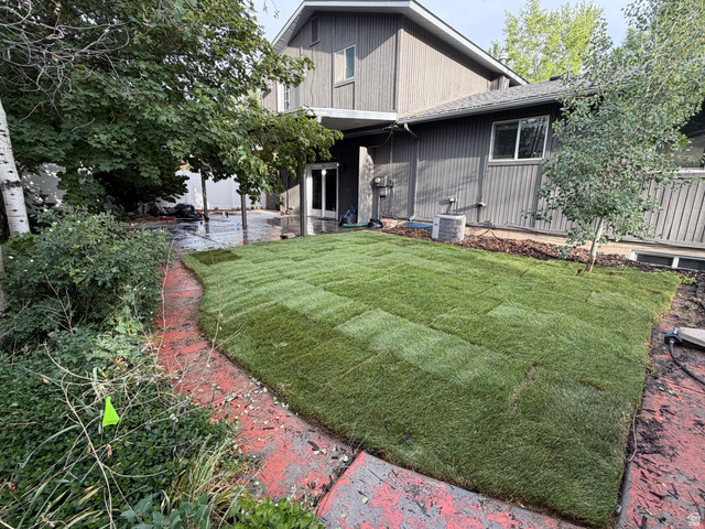 2163 Borg Drive Sandy, UT 84092 - Photo 28 of 31 Private backyard with newly laid sod, mature trees, and a red-toned concrete patio