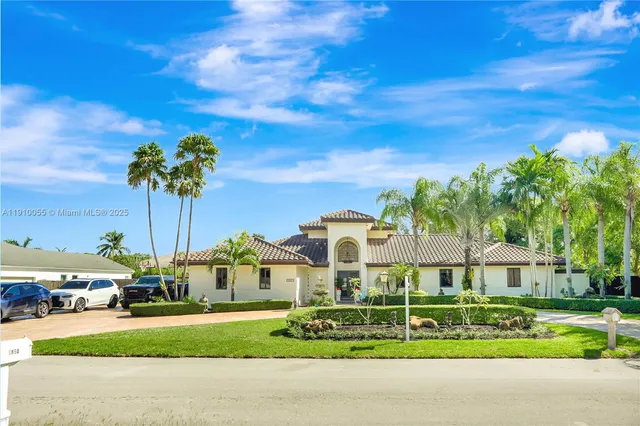 a view of a white house with a yard and plants