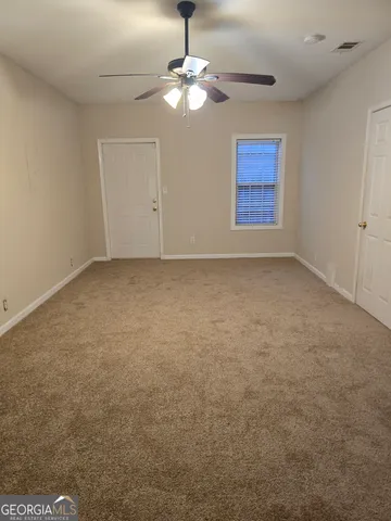 an empty room with chandelier fan