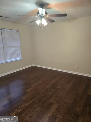 a view of a room with wooden floor and fan