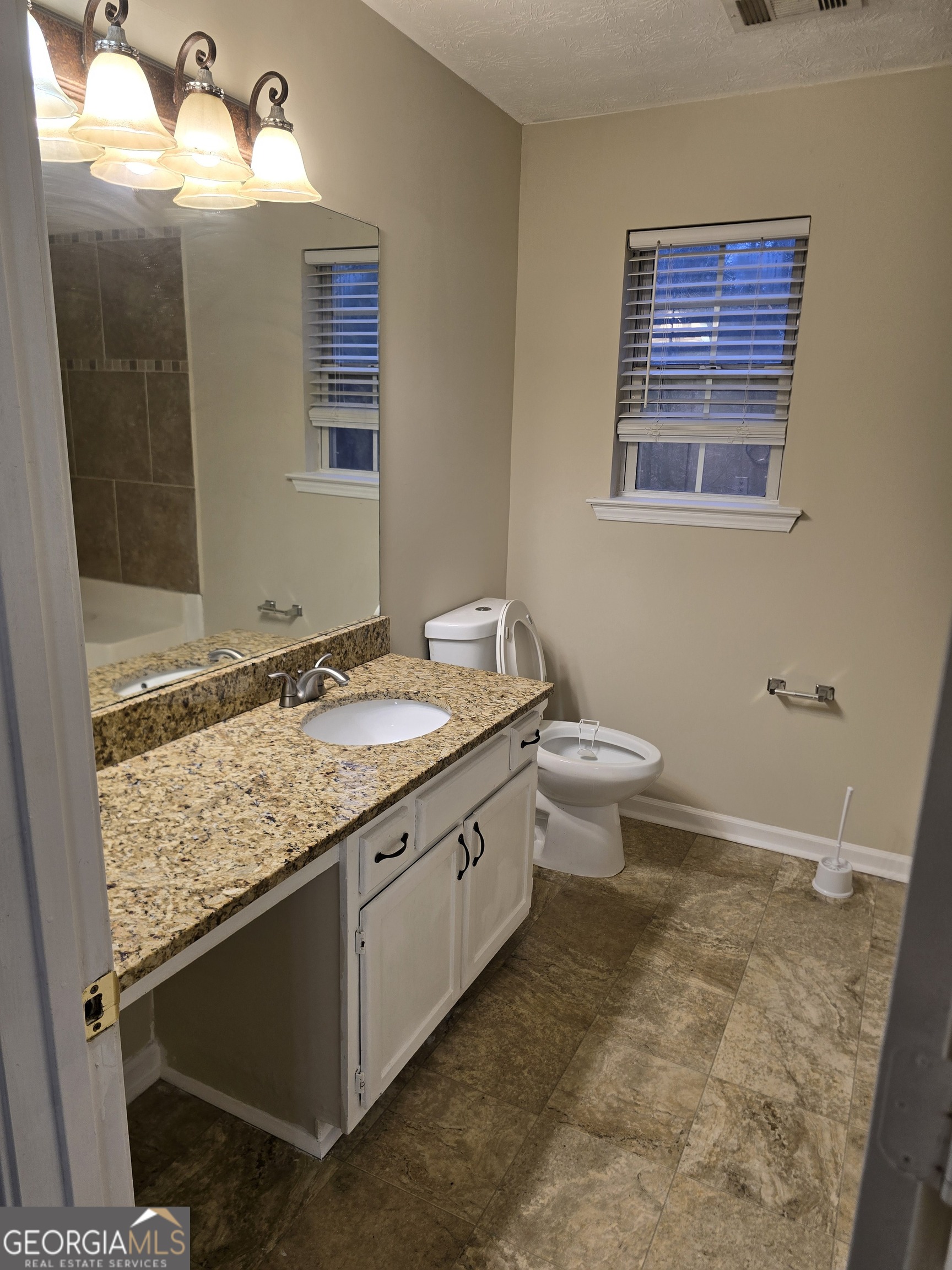 2727 Manor Cove Decatur, GA 30034 - Photo 4 of 16 a bathroom with a granite countertop sink a toilet and mirror