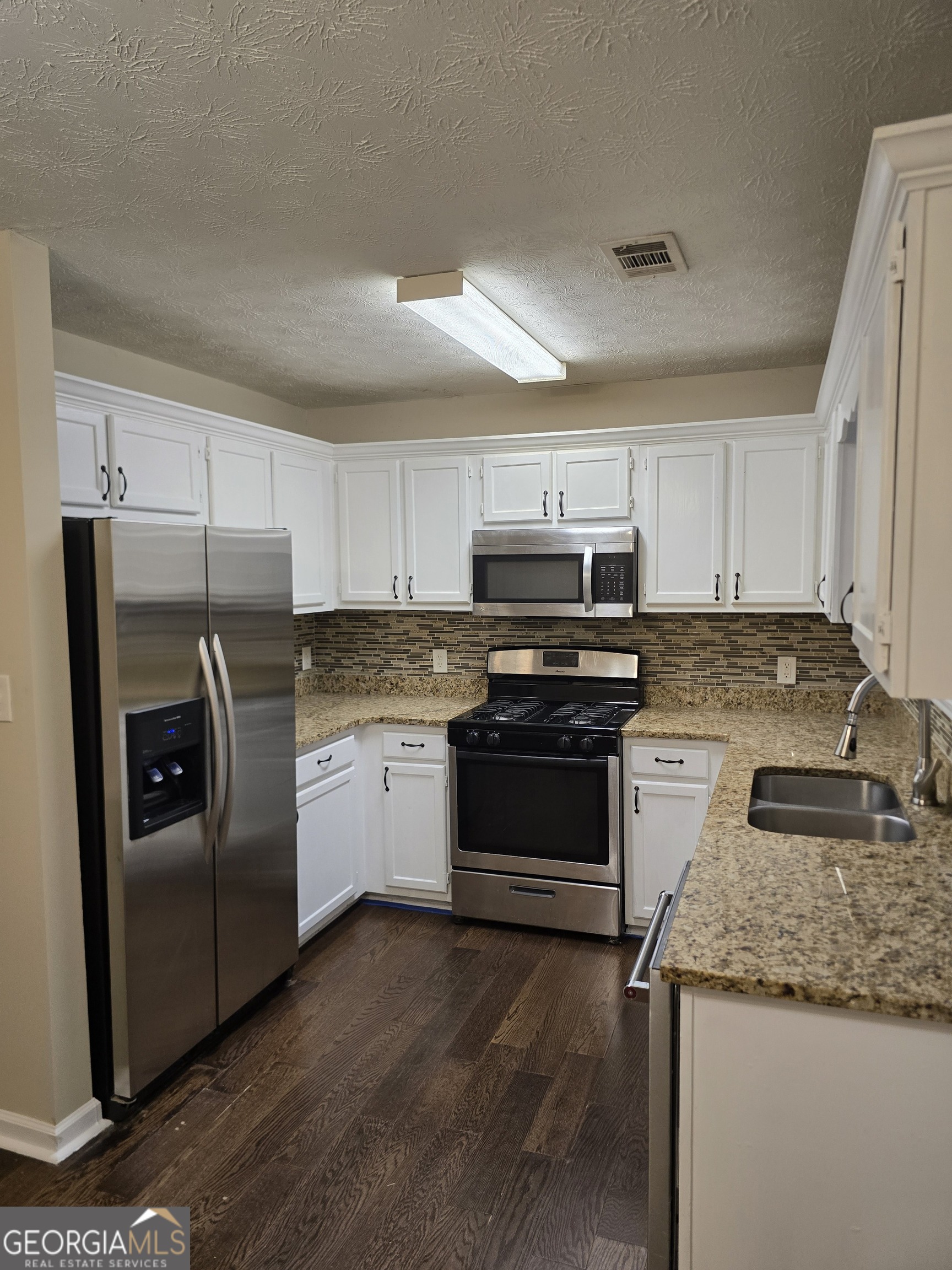 2727 Manor Cove Decatur, GA 30034 - Photo 10 of 16 a kitchen with granite countertop stainless steel appliances and white cabinets