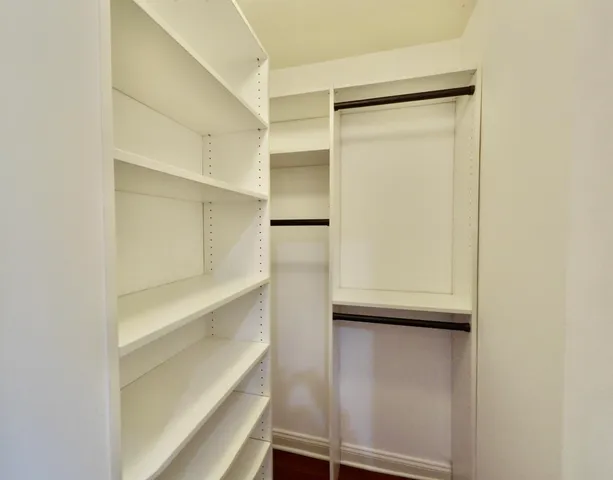 a view of walk in closet with empty racks