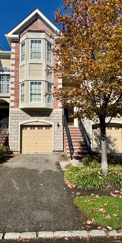 a view of a house with a yard and large tree