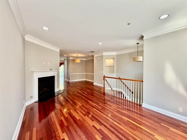 a view of a livingroom with wooden floor and a fireplace
