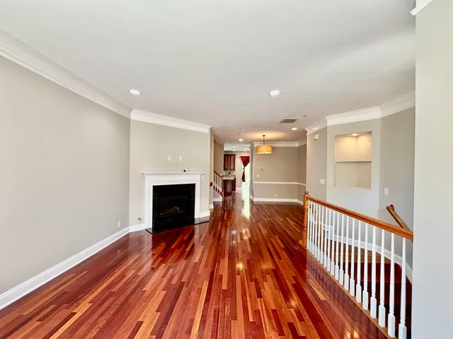 a view of a room with wooden floor fireplace and window