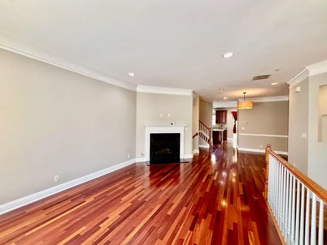 a view of a livingroom with wooden floor and a fireplace