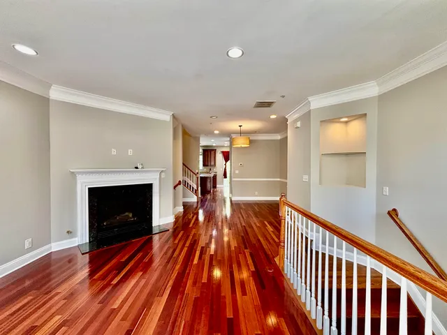 a view of a livingroom with wooden floor and a fireplace