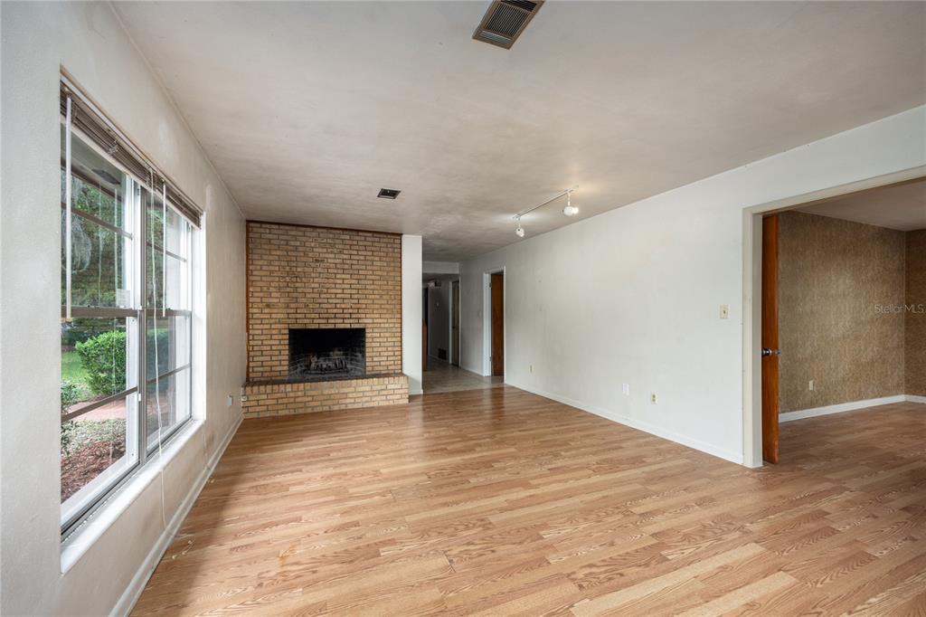 2147 Northwest 7th Place Gainesville, FL 32603 - Photo 11 of 50 a view of an empty room with a fireplace and a window