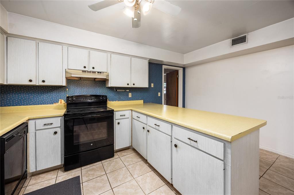 2147 Northwest 7th Place Gainesville, FL 32603 - Photo 19 of 50 a kitchen with stainless steel appliances granite countertop a sink and dishwasher a stove top oven with white cabinets