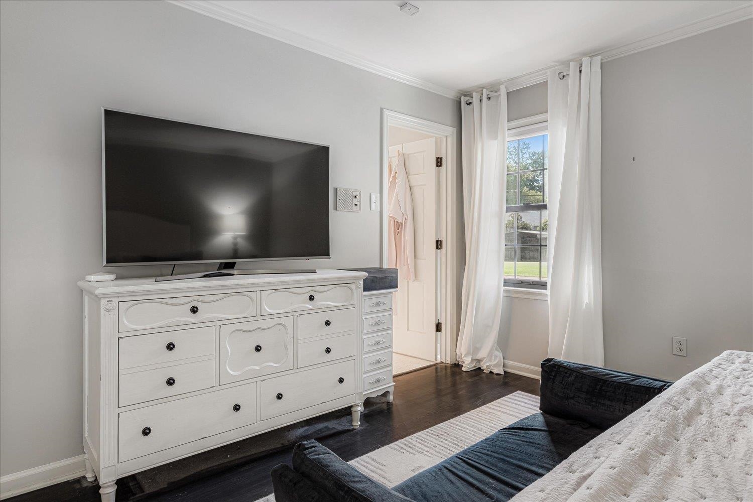 5429 Walnut Grove Road Memphis, TN 38120 - Photo 20 of 37 a living room with flat screen tv on dresser and a window