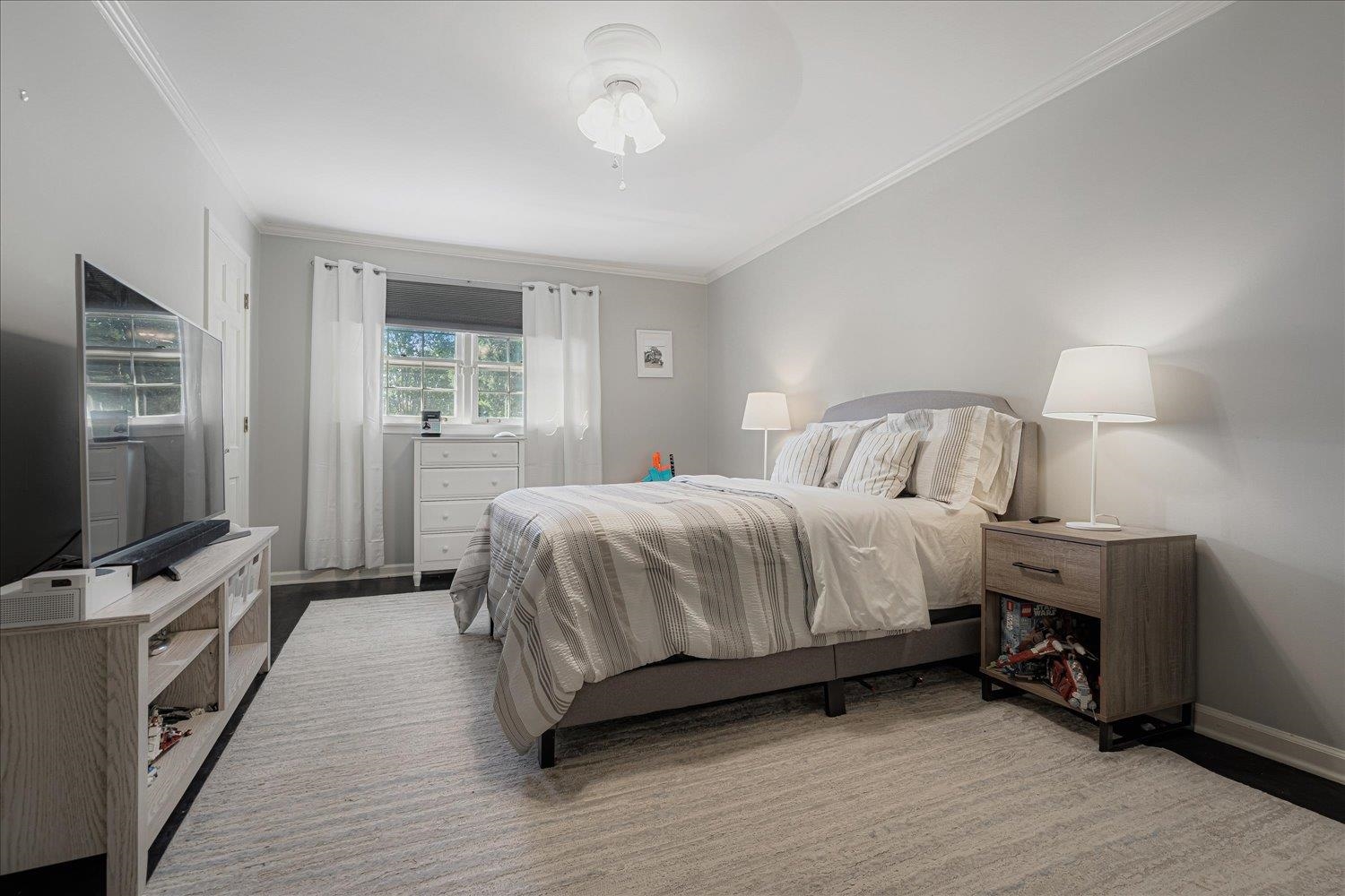 5429 Walnut Grove Road Memphis, TN 38120 - Photo 27 of 37 a bedroom with a bed and a flat tv screen on wall