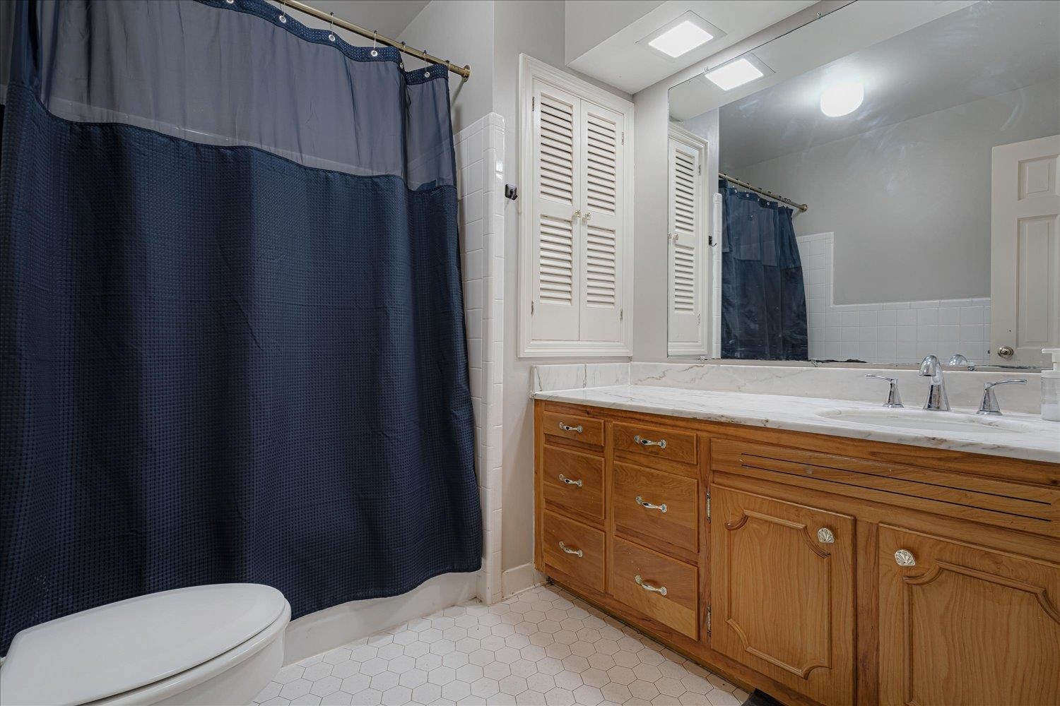 5429 Walnut Grove Road Memphis, TN 38120 - Photo 28 of 37 a bathroom with a sink a toilet a mirror and shower curtain