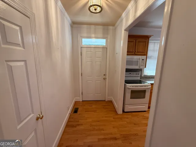 a kitchen that has a sink wooden floor stainless steel appliances and cabinets