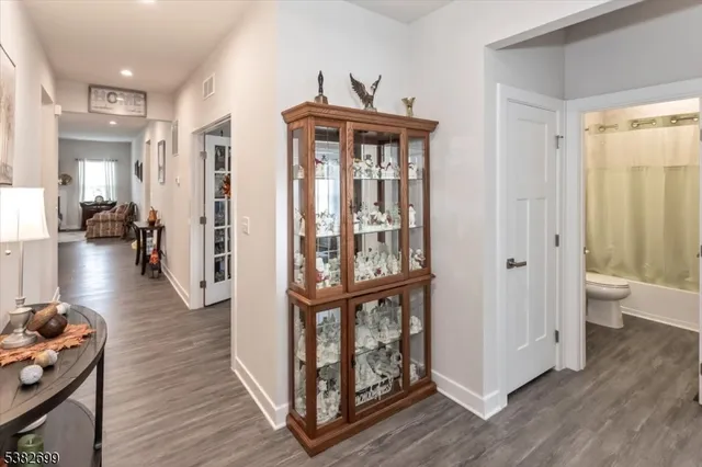 a view of a hallway with wooden floor and windows
