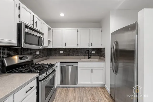 a kitchen with stainless steel appliances granite countertop a stove a refrigerator and a microwave