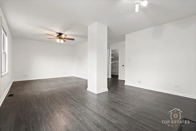 an empty room with wooden floor and window