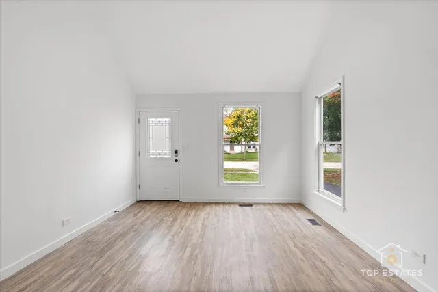 an empty room with a window and wooden floor