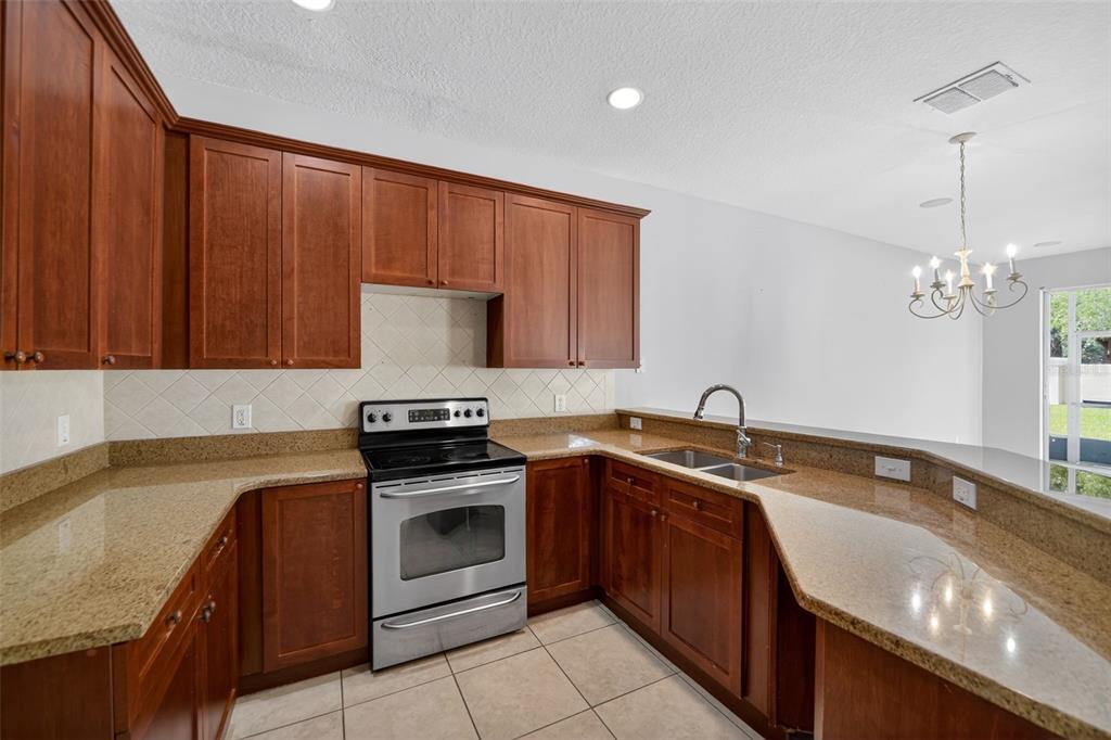 6071 Strada Isle Way Orlando, FL 32835 - Photo 19 of 29 a kitchen with a sink stove and cabinets