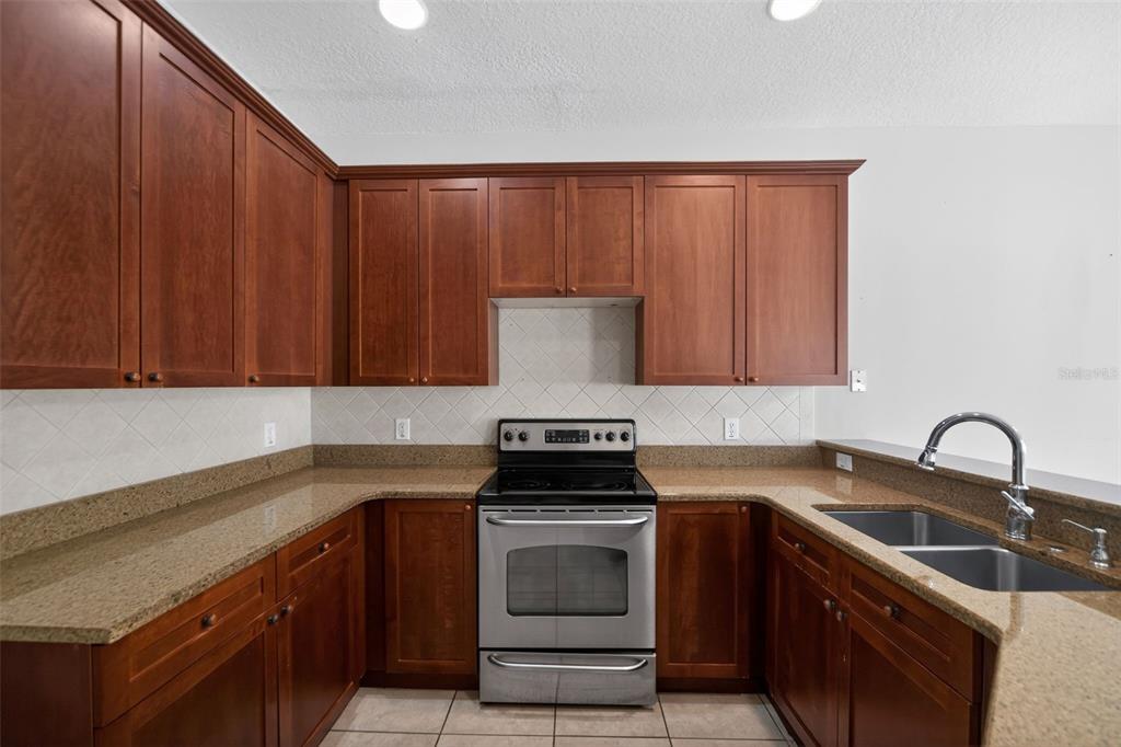 6071 Strada Isle Way Orlando, FL 32835 - Photo 21 of 29 a kitchen with a sink stove top oven and cabinets
