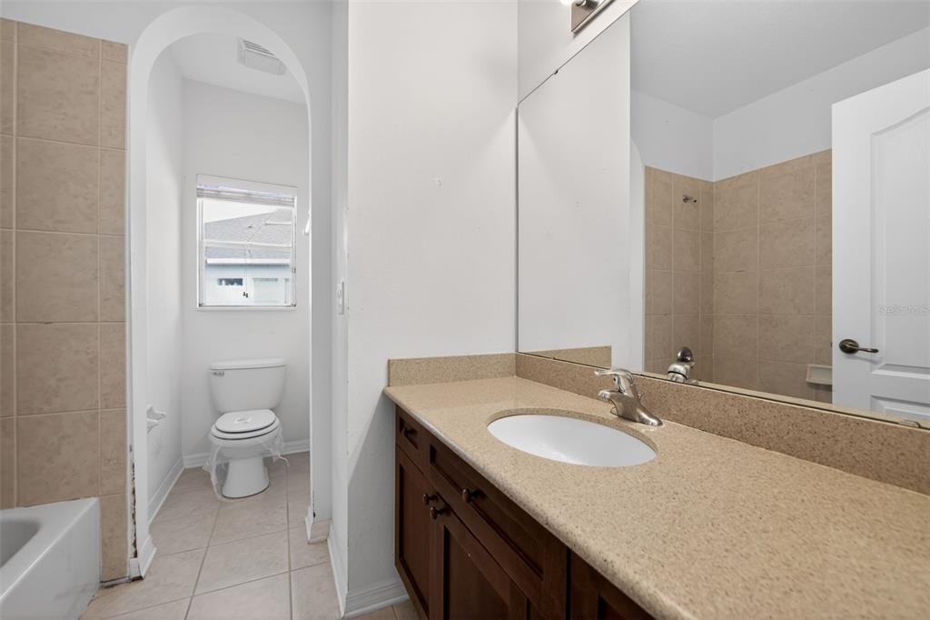 6071 Strada Isle Way Orlando, FL 32835 - Photo 23 of 29 a bathroom with a granite countertop sink toilet and a mirror