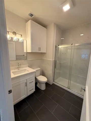 a bathroom with a double vanity sink toilet and shower