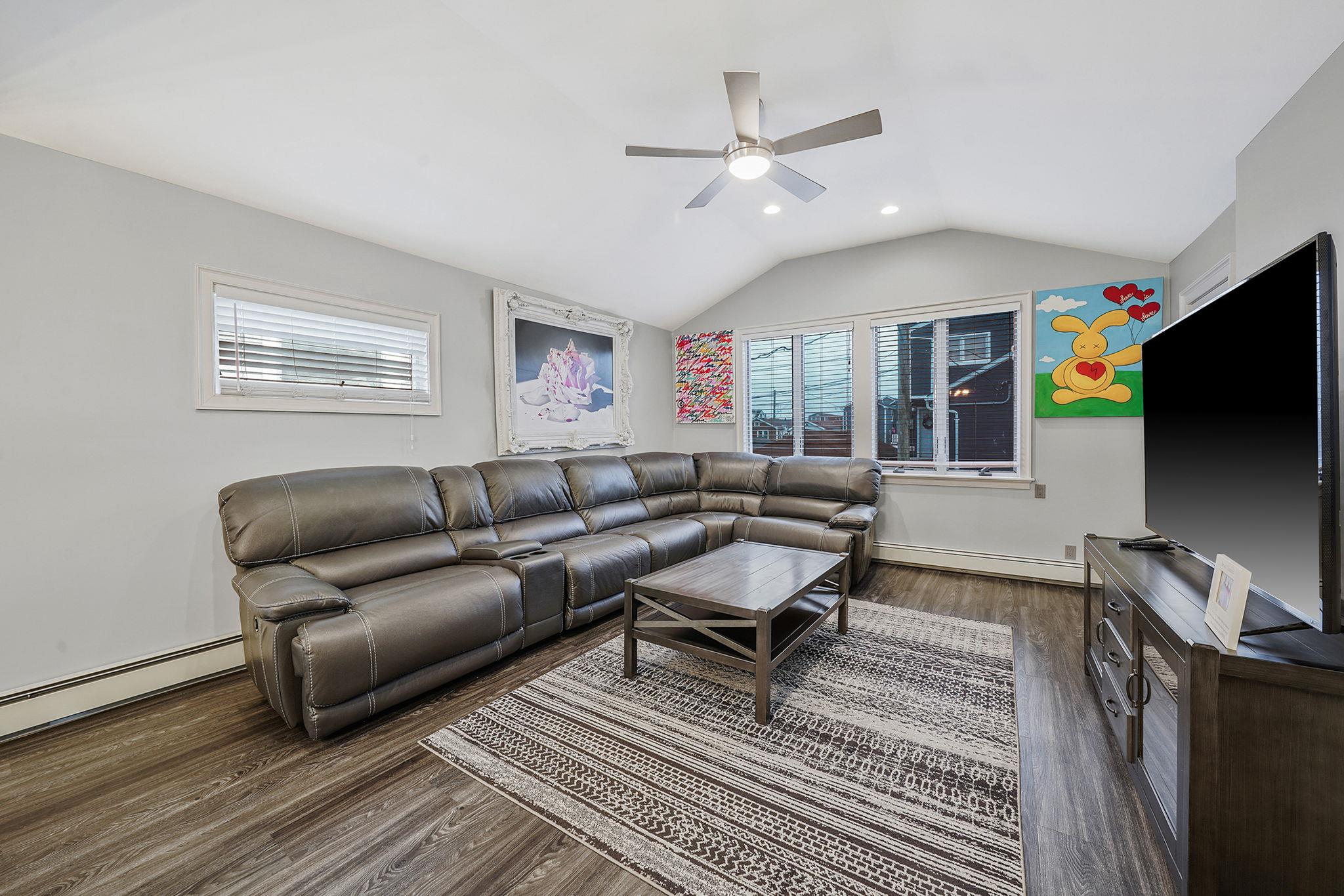 28 West 13th Road Queens, NY 11693 - Photo 22 of 37 a living room with furniture a flat screen tv and kitchen view