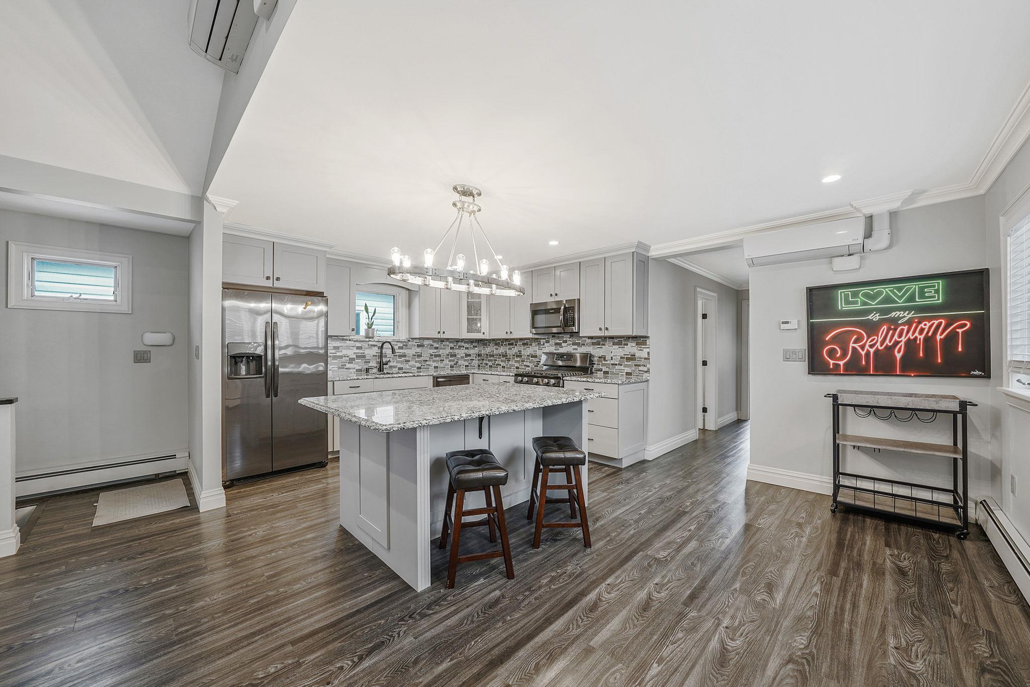 28 West 13th Road Queens, NY 11693 - Photo 24 of 37 a kitchen with kitchen island white cabinets and stainless steel appliances