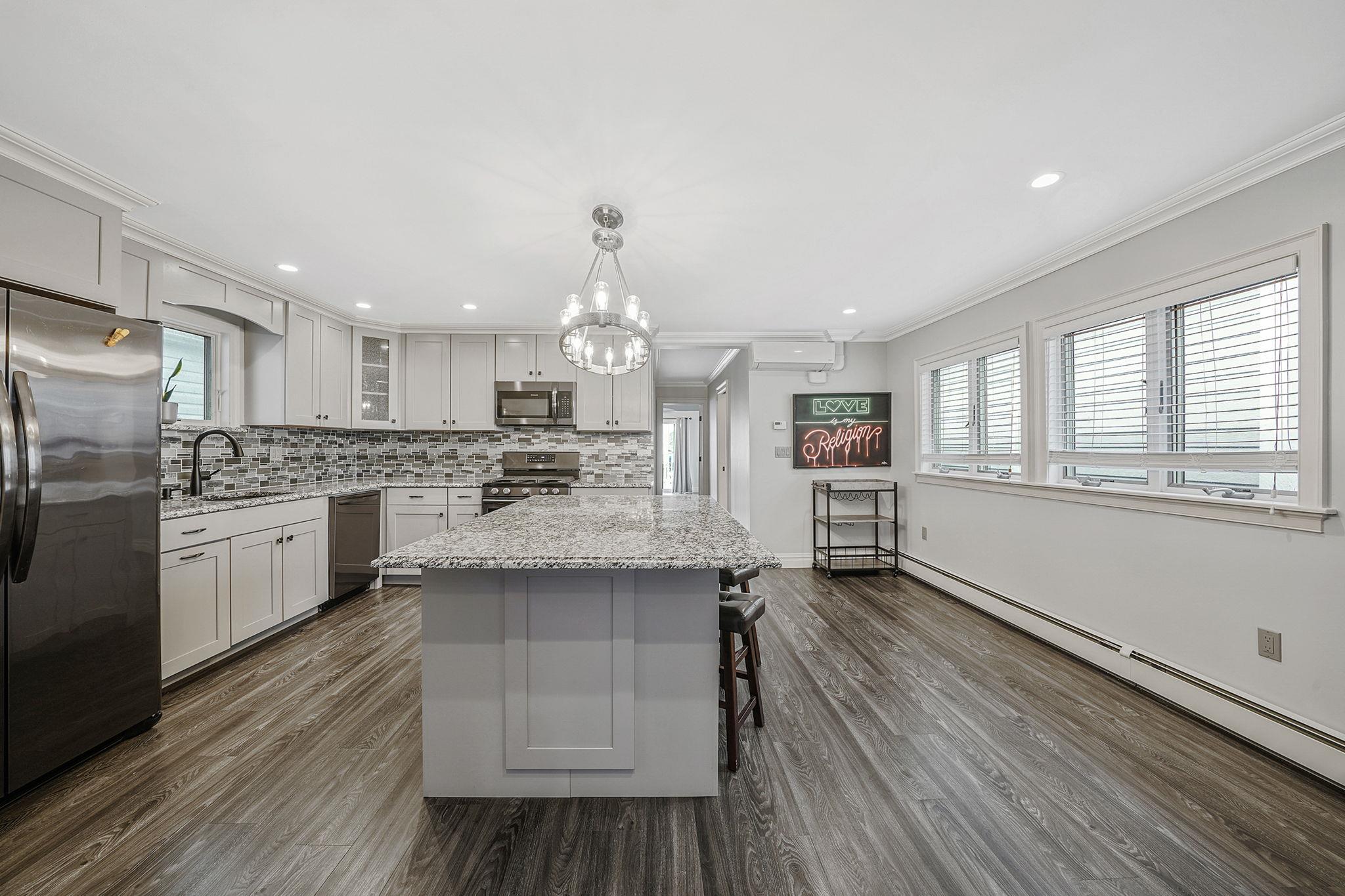 28 West 13th Road Queens, NY 11693 - Photo 26 of 37 a kitchen with stainless steel appliances kitchen island hardwood floor sink stove and wooden cabinets