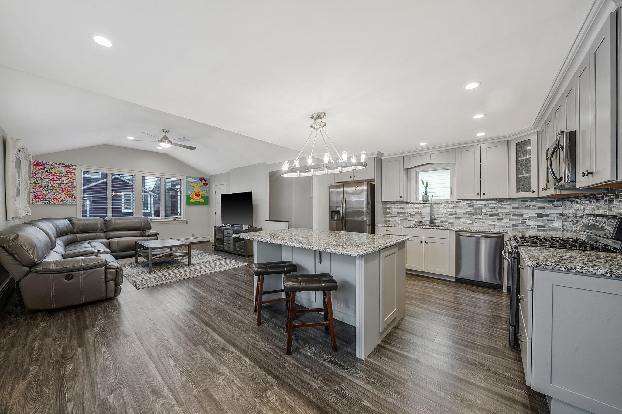 28 West 13th Road Queens, NY 11693 - Photo 36 of 37 a living room with furniture a fireplace a flat screen tv and kitchen view