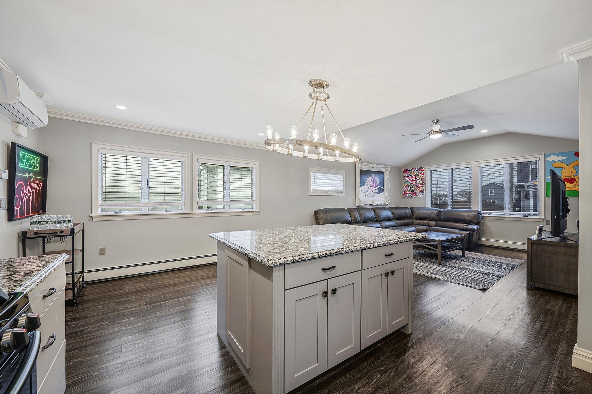 28 West 13th Road Queens, NY 11693 - Photo 37 of 37 a kitchen with stainless steel appliances granite countertop a stove top oven a sink dishwasher and white cabinets with wooden floor