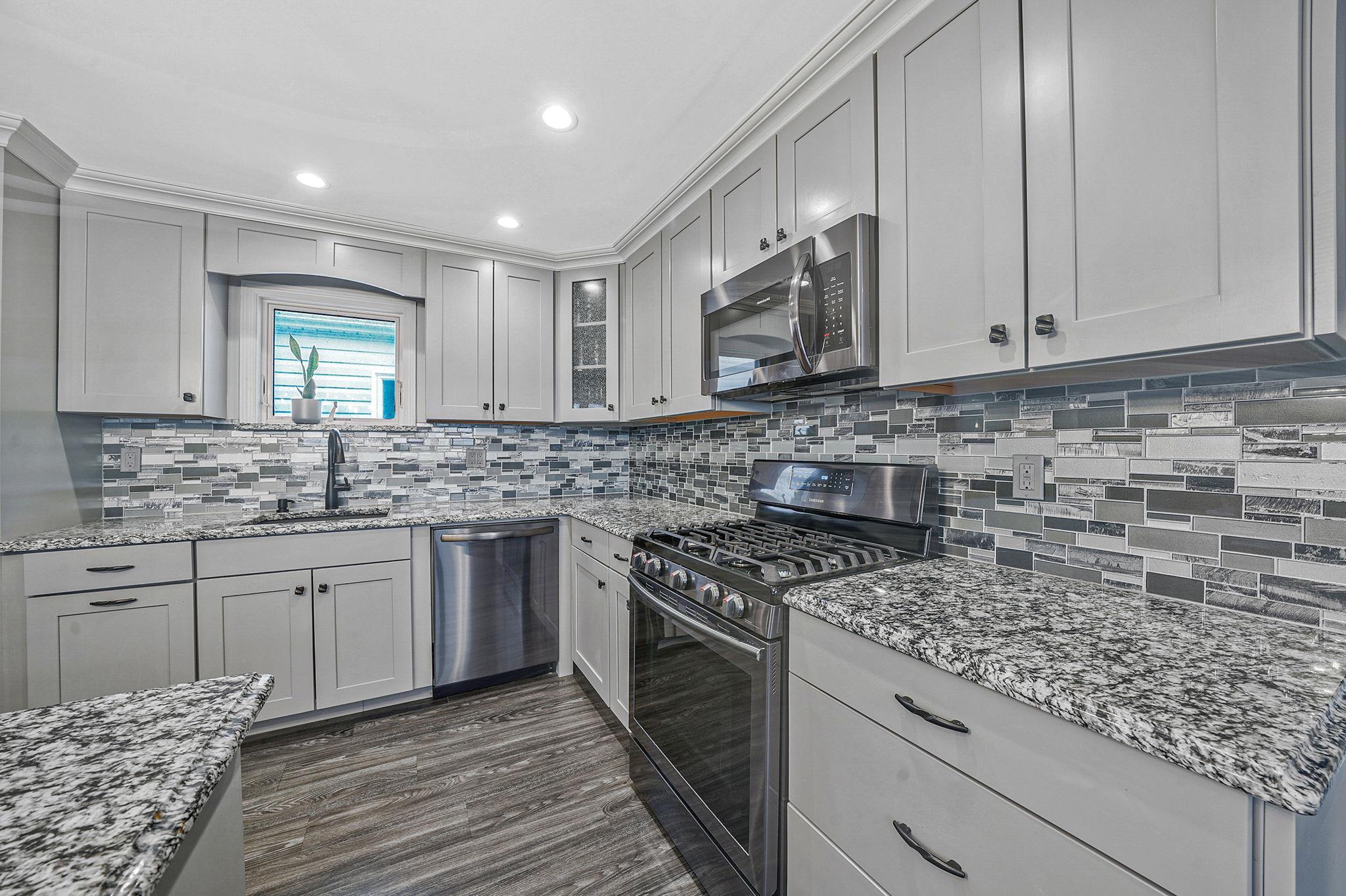 28 West 13th Road Queens, NY 11693 - Photo 27 of 37 a kitchen with stainless steel appliances granite countertop a stove sink and cabinets