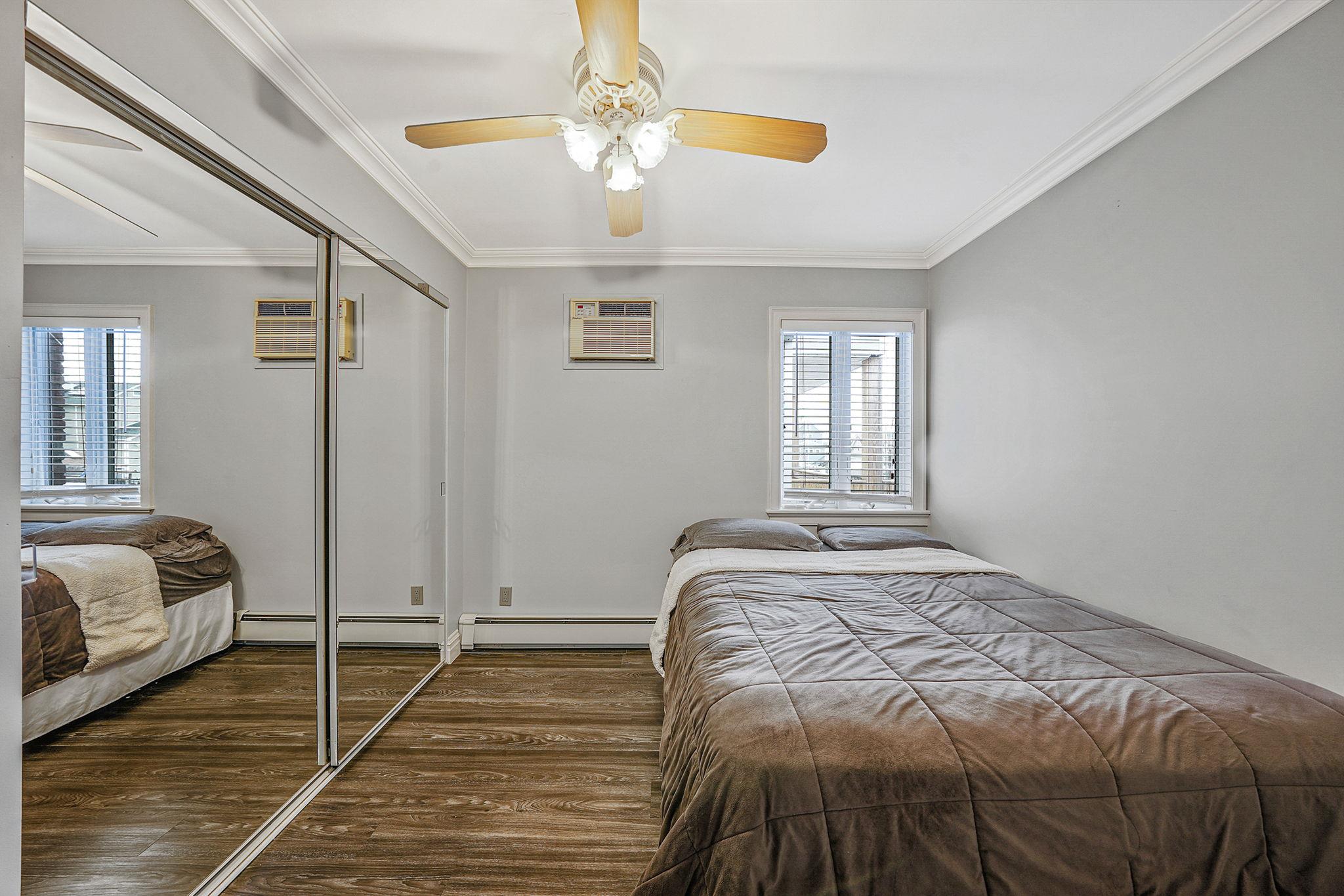 28 West 13th Road Queens, NY 11693 - Photo 28 of 37 a bedroom with a large bed and a chandelier