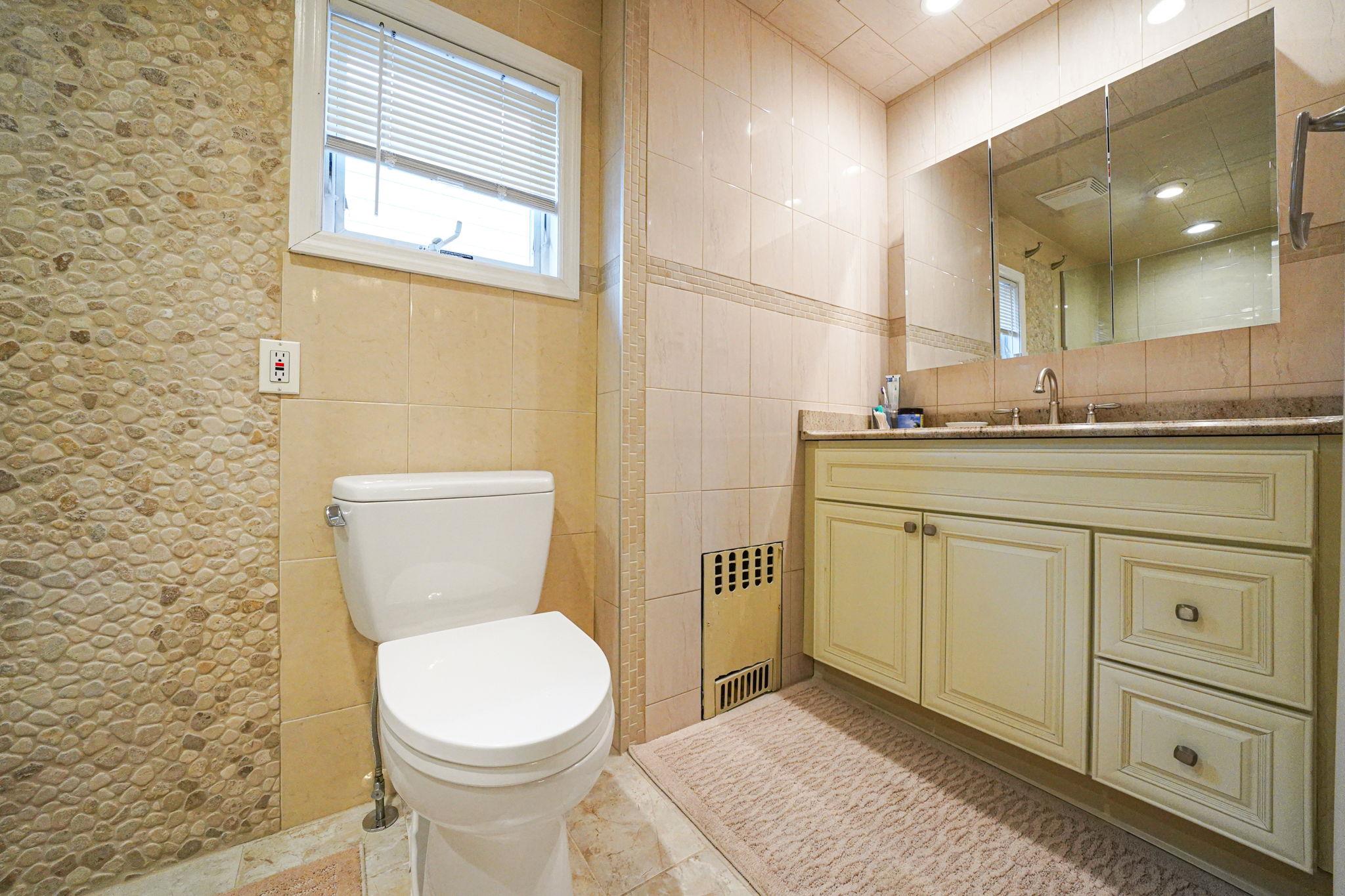 28 West 13th Road Queens, NY 11693 - Photo 33 of 37 a bathroom with a granite countertop toilet sink and mirror