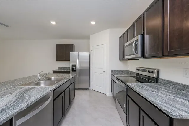 a kitchen with granite countertop stainless steel appliances and wooden cabinets