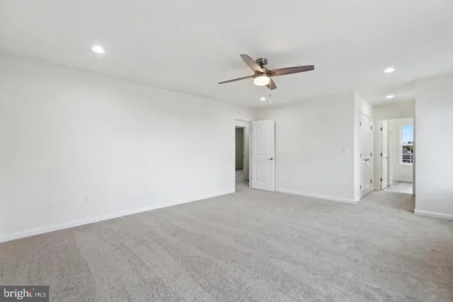 a view of an empty room with a ceiling fan