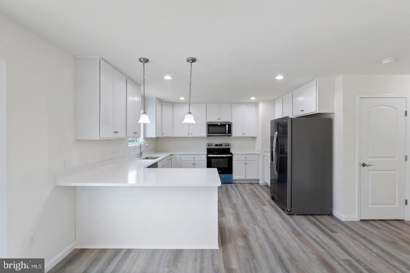 144 Pratts Branch Road Felton, DE 19943 - Photo 6 of 24 a kitchen with stainless steel appliances granite countertop a refrigerator a sink a stove and oven with wooden floor