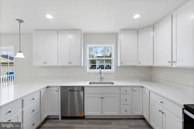 a kitchen with white cabinets white stainless steel appliances and sink